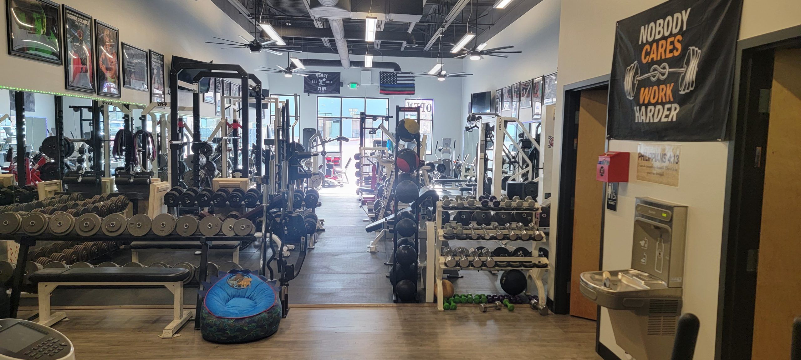 Rows of dumbbells, squat racks and medicine balls beneath a banner that reads Nobody Cares, Work Harder